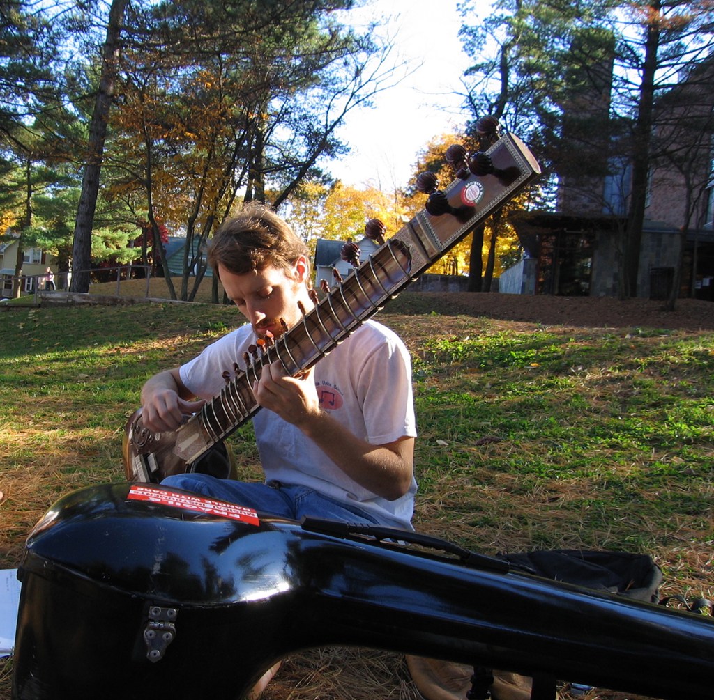 Woody Leslie playing sitar outdoors