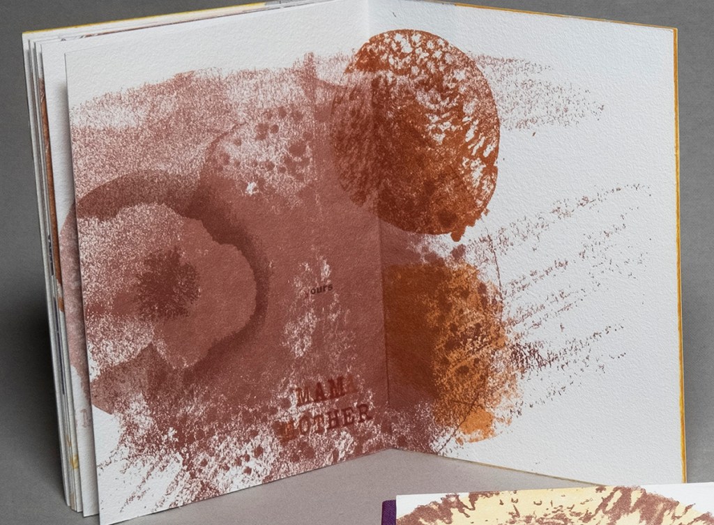 Inside spread of the book MAMA-SELF, standing up and open. Rough red shapes overlap below text that reads "ours / MAMA / MOTHER"