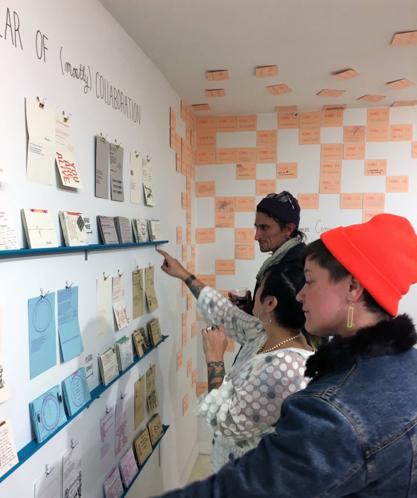 Hope Amico converses with viewers about her work in a gallery. 