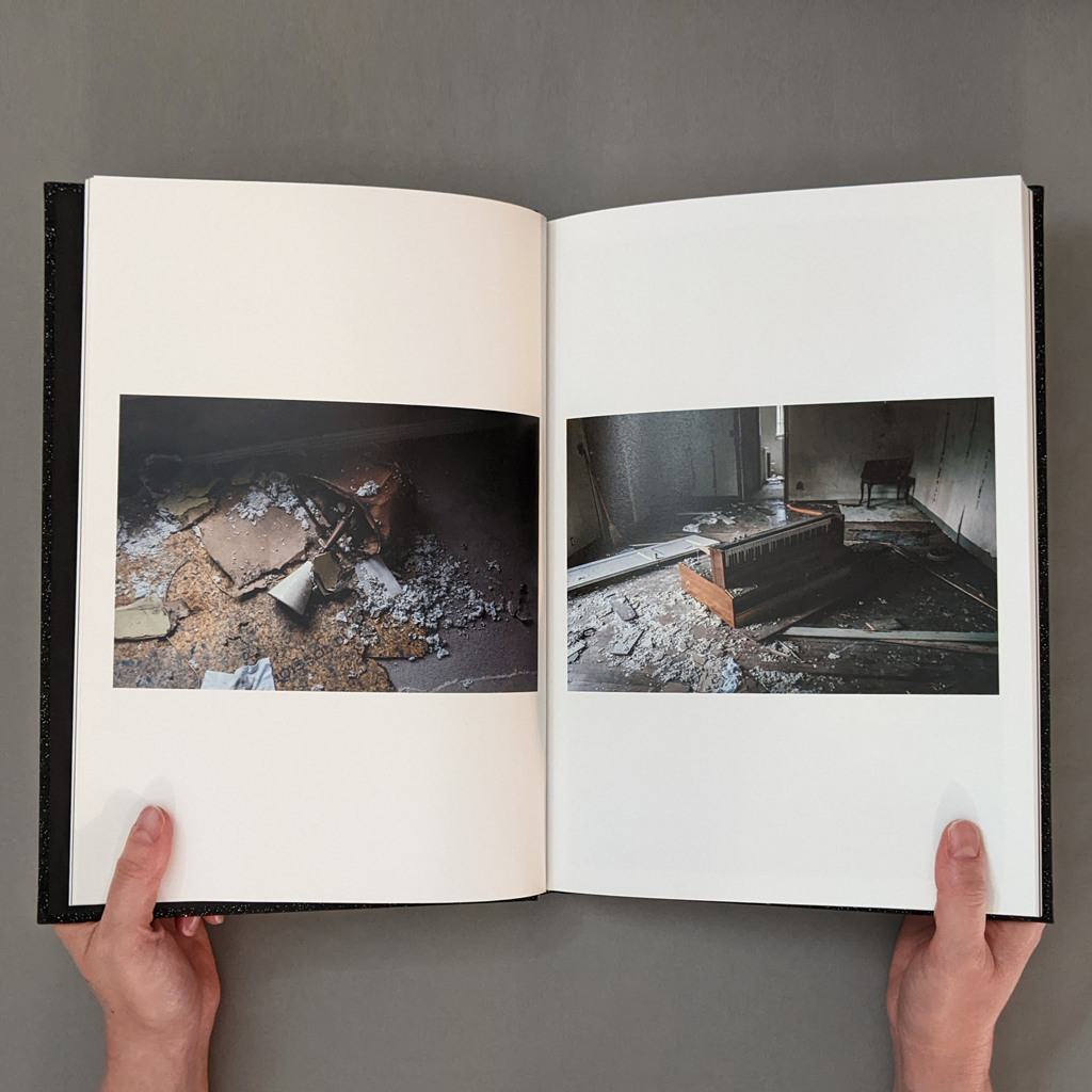 A Ghost Story: Photographs, inside spread. Verso and recto show horizontal photographs of broken furniture and demolition detritus in a derelict indoor space, with ample white space above and below.
