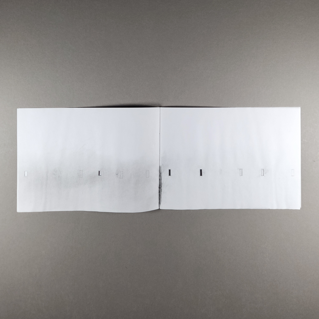 Warten, inside spread: a row of hand-cut rectangles in white pages with graphite smudges.